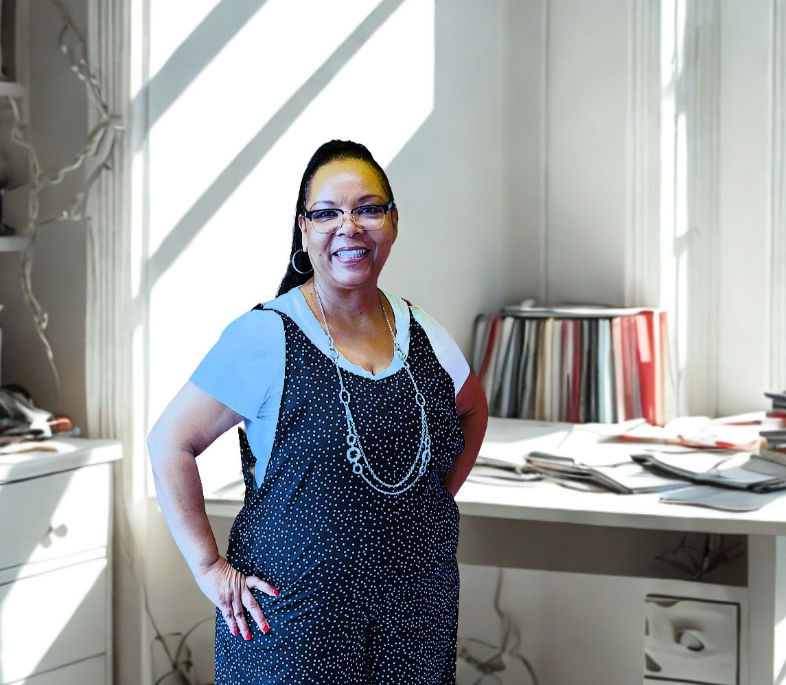 Andrea J. Brown smiling in her sunlit study